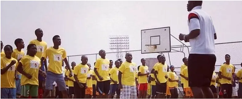 Young Nigerian players at a basketball training session with their coach