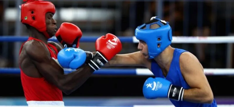 Two amateur boxers in headguards trading punches
