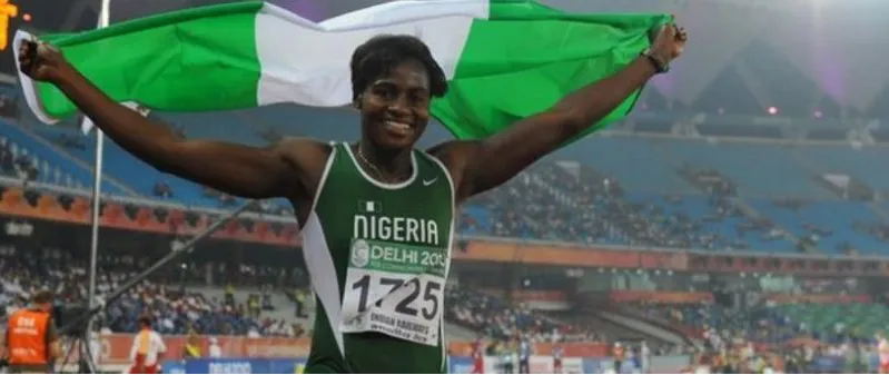 A Nigerian sprinter celebrating with the flag at the Delhi 2010 Commonwealth Games