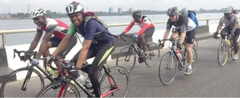 Riders cycling along a Lagos waterfront road