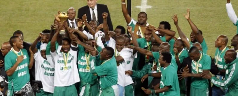 Nigerian players celebrating an AFCON title with the trophy