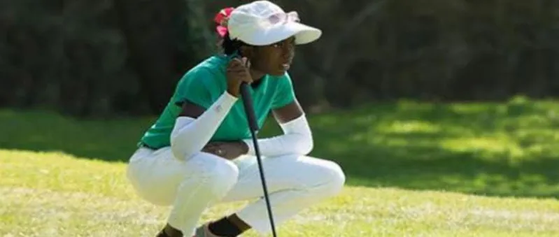 A young Nigerian golfer lining up a putt