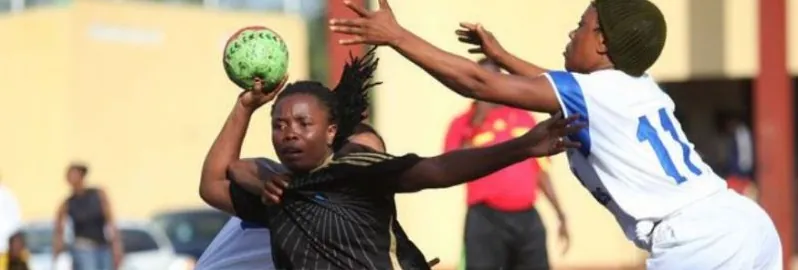 A Nigerian women's handball player shooting under pressure from a defender