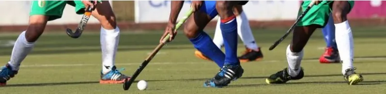 Players chasing the ball with their sticks on the pitch