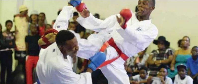 Two Nigerian karatekas in a kumite bout watched by a crowd