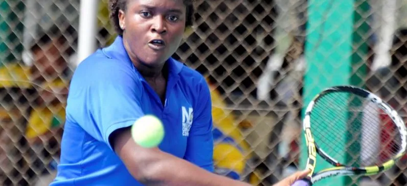 A Nigerian woman player hitting a forehand through the fence