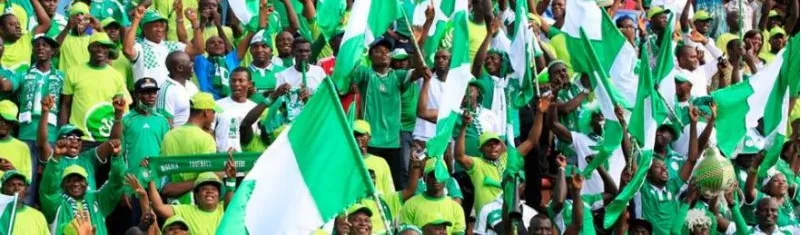 Nigerian fans waving flags at a major games