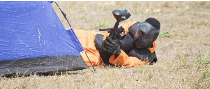 A player lying prone and aiming beside a tent