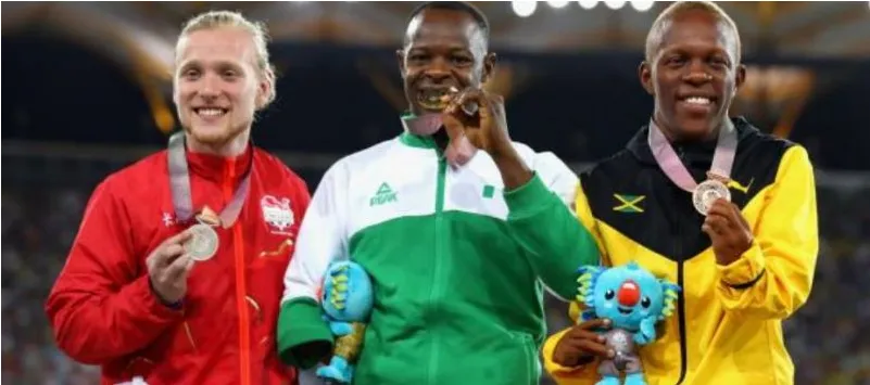 A Nigerian para sprinter on the podium between rivals from Poland and Jamaica