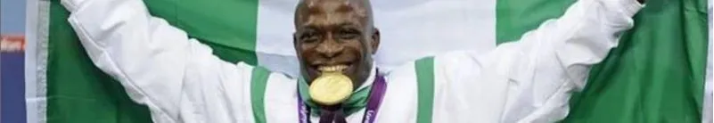 A Nigerian Paralympic champion with the national flag and gold medal