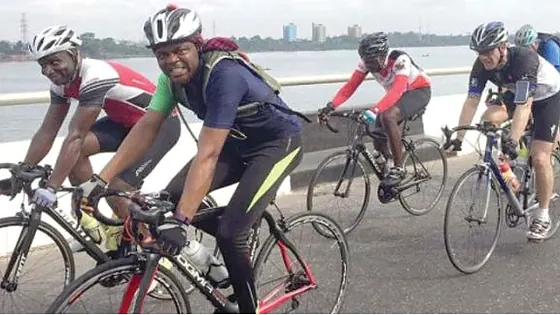 Road cyclists racing along a Nigerian waterfront