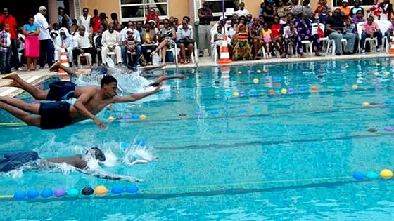 Swimmers racing in an outdoor pool