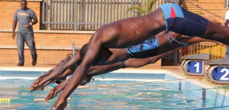Young Nigerian swimmers diving in at the start of a race