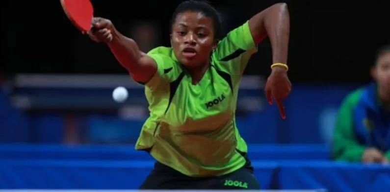 A Nigerian woman stretching for a forehand at an international event