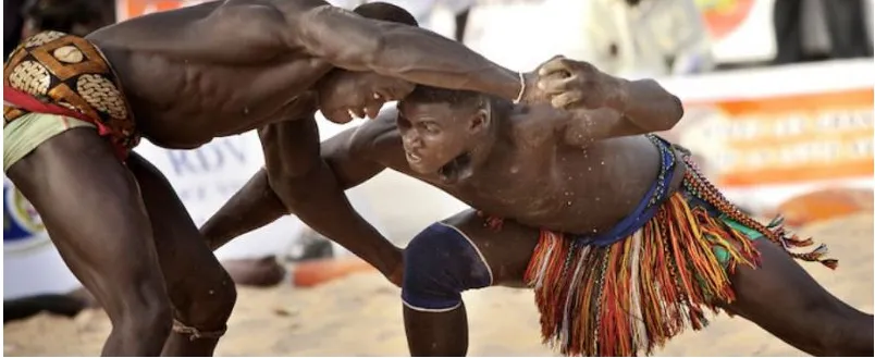 Traditional wrestlers grappling on sand